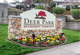 A sign for a retirement community is located on the sidewalk. AI generated content